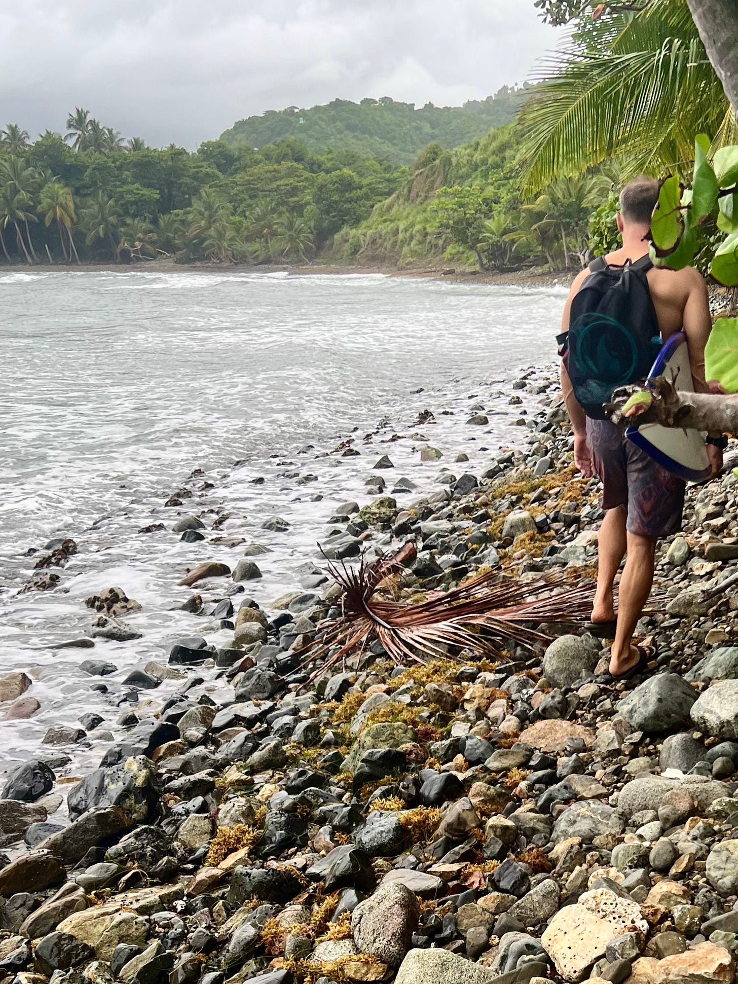 Picture of Nat Sharratt living his surf adventure dream hiking with friends to a secret surf spot