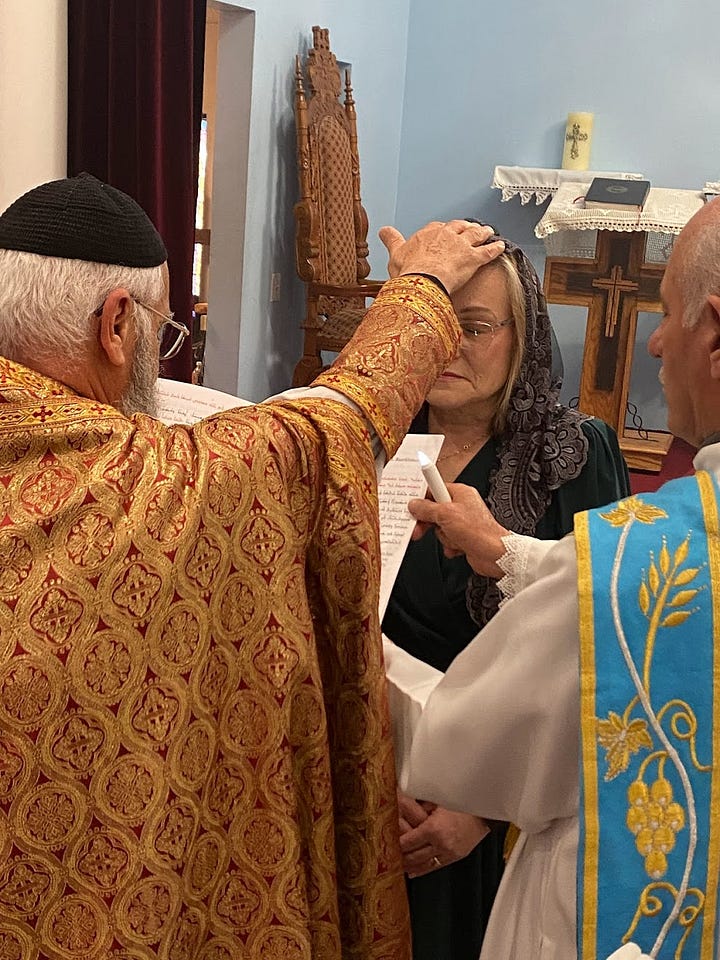 A priest blessing a woman and giving her communion