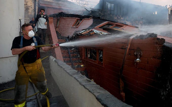 Chester Griffiths and his son Chester jnr in the middle of their battle to stop the wildfires in Malibu engulfing their street Chester Griffiths and his son Chester jnr in the middle of their battle to stop the wildfires in Malibu engulfing their street