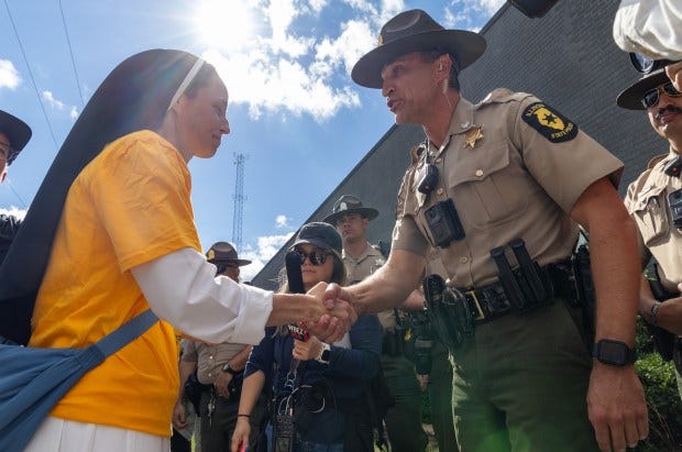 Dominican sister Christin Tomy, left, thanks Illinois State Police Lt....