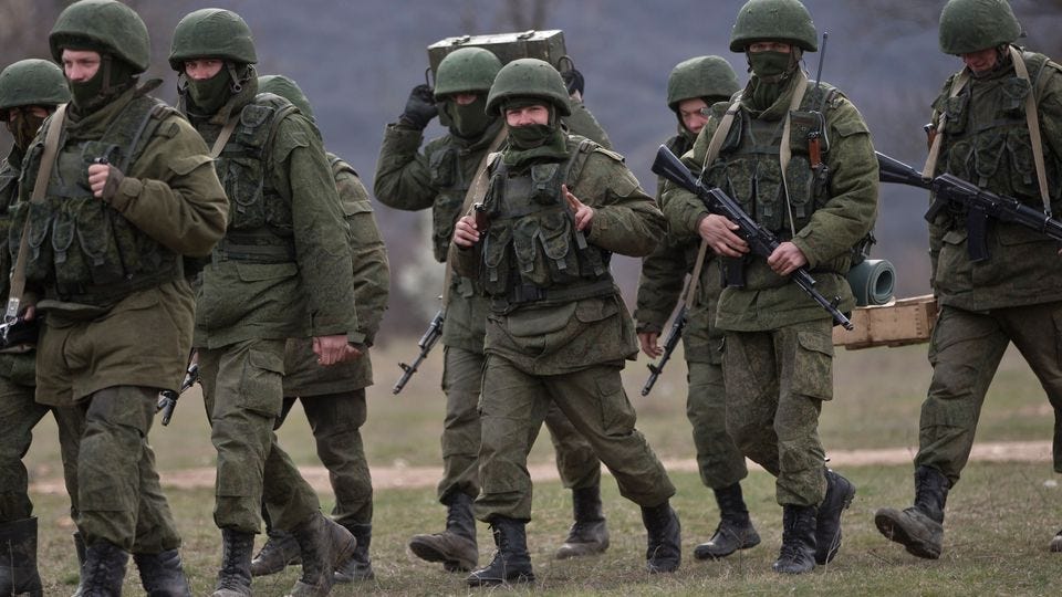 "Little green men": Pro-Russian soldiers are seen marching near a Ukrainian army base in Perevalne, Crimea, on March 19.