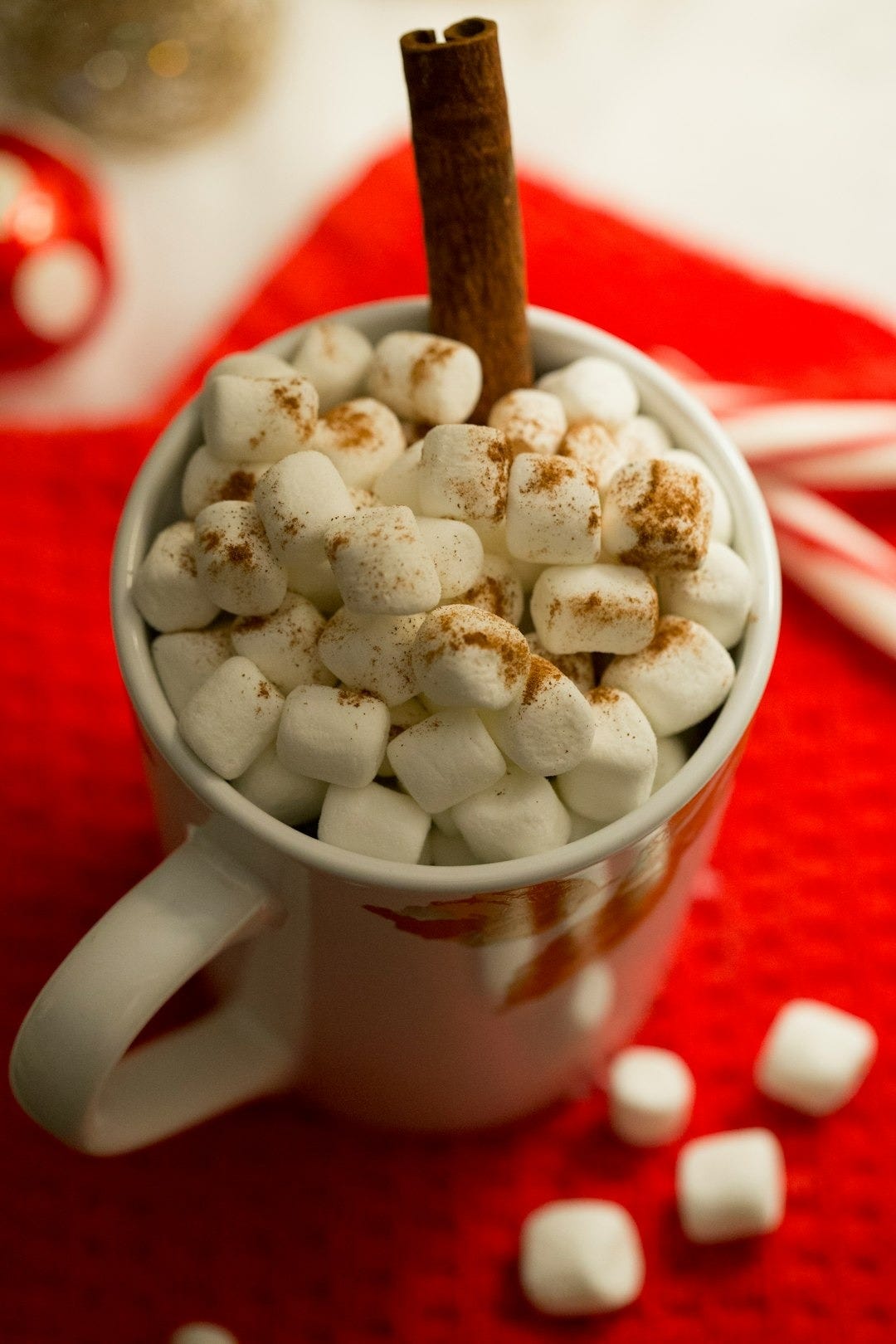 a cup of hot chocolate with marshmallows and a cinnamon stick a cup of hot chocolate with marshmallows and a cinnamon stick
