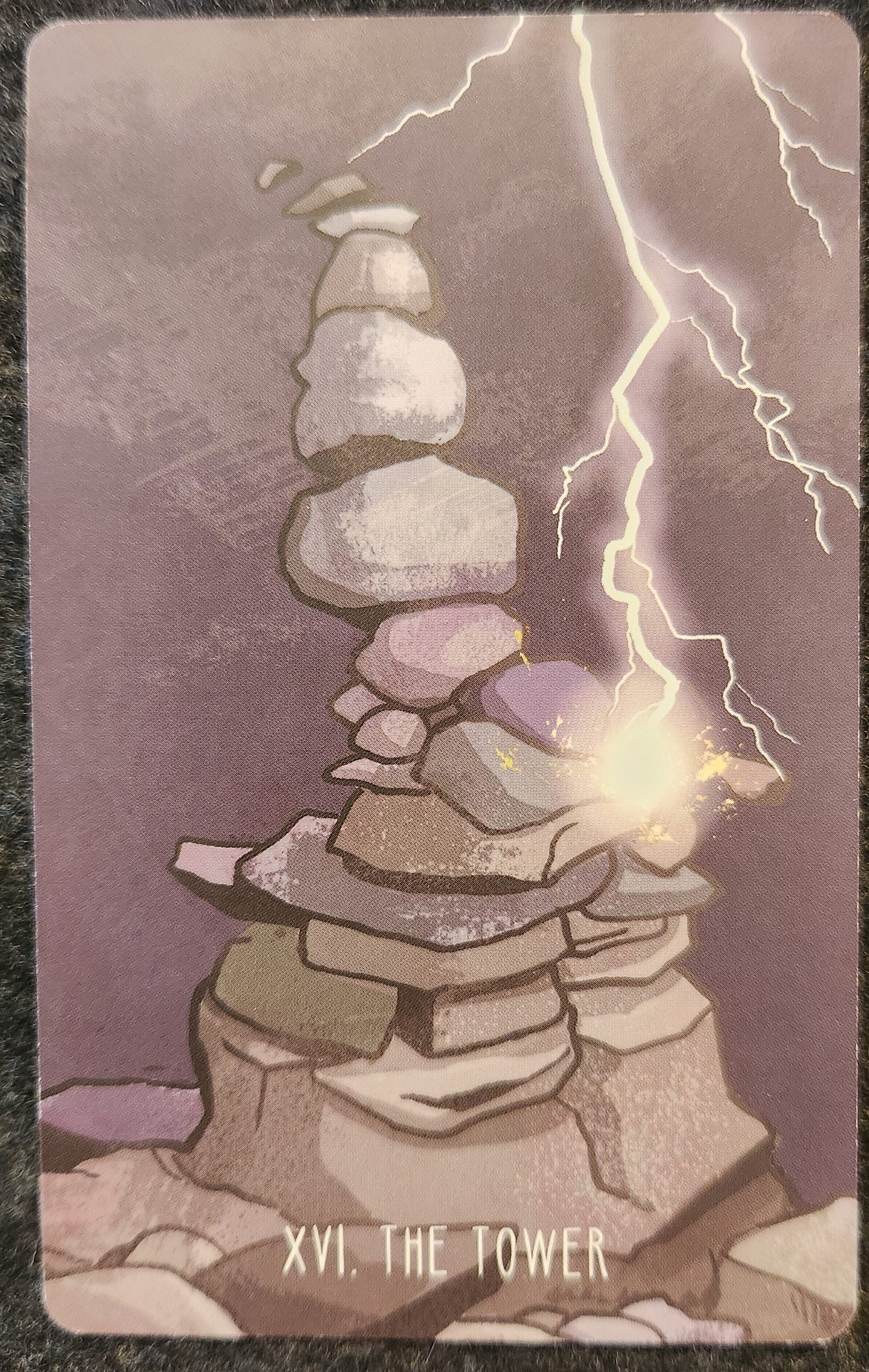 A tarot card labelled XV. The Tower. A tall structure of stacked rocks and stones which has been hit by multiple bolts of lightning. 