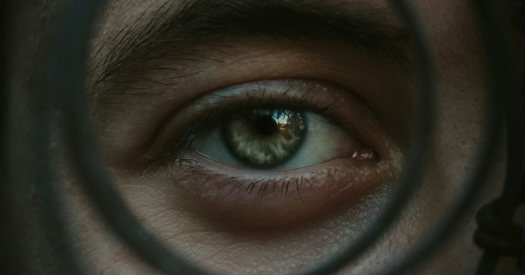 a close up of a person's eye through a magnifying glass a close up of a person's eye through a magnifying glass