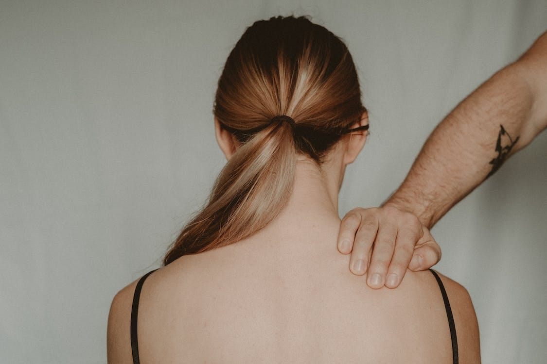 Free Back view of anonymous female sitting on white background while being touched by strong faceless abusive man in light room Stock Photo Free Back view of anonymous female sitting on white background while being touched by strong faceless abusive man in light room Stock Photo