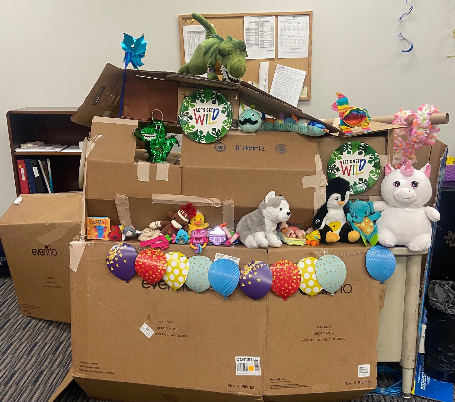 photo of a cardboard fort over a desk, filled with toys and decorations