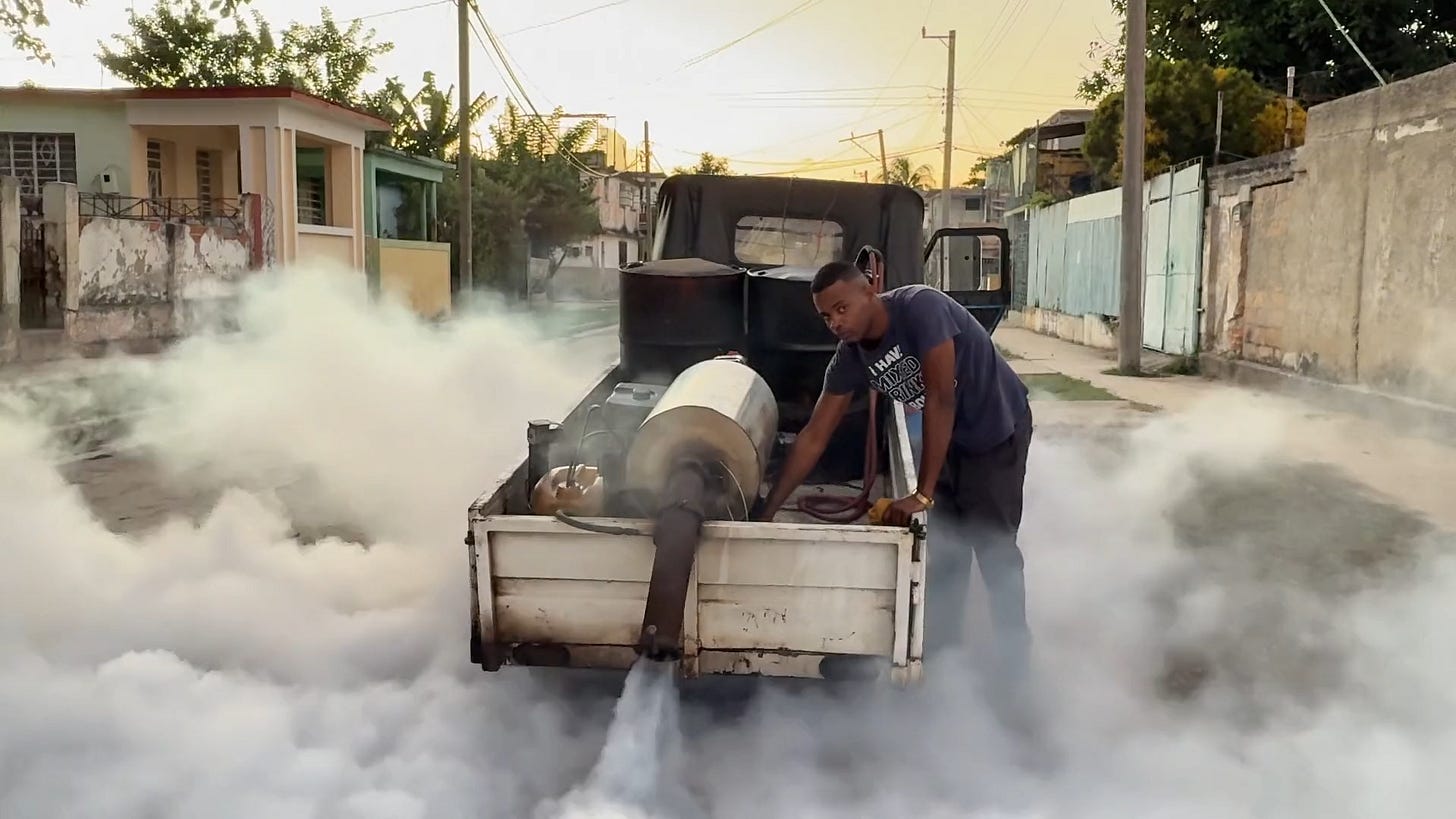 A worker operates a fumigation machine mounted on a truck as thick white smoke fills a residential street at sunset, captured in spatial video for Primary's immersive journalism platform.