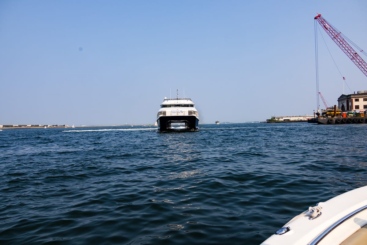 High-speed ferry hydrofoil viewed head-on as it travels through Boston Harbor on a sunny day