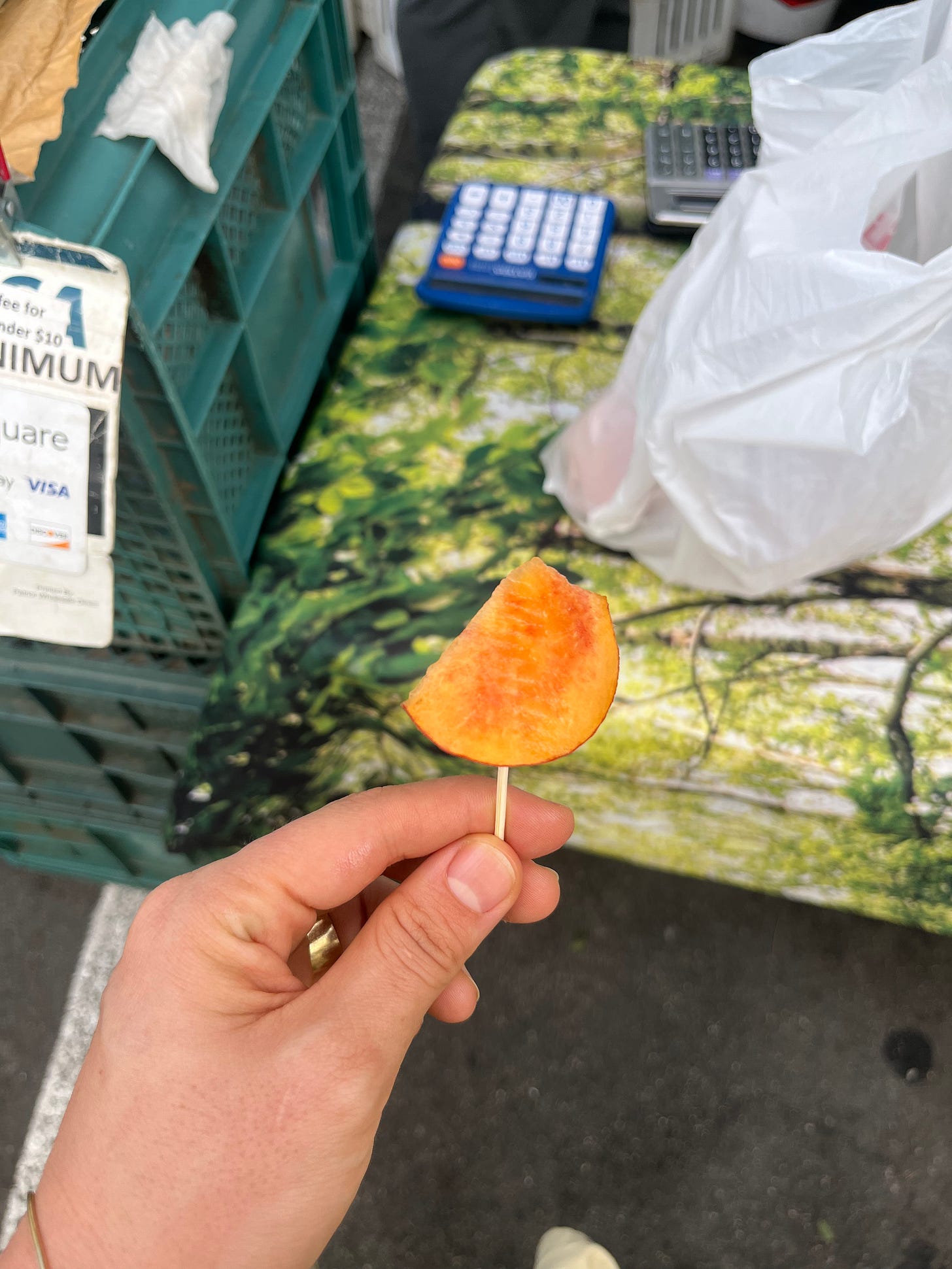 A slice of peach on a toothpick.
