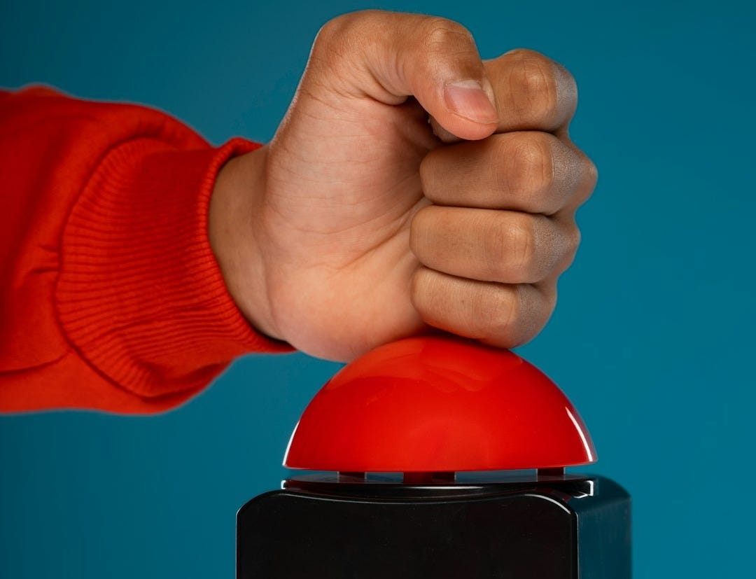 Hand pressing a large red button Hand pressing a large red button