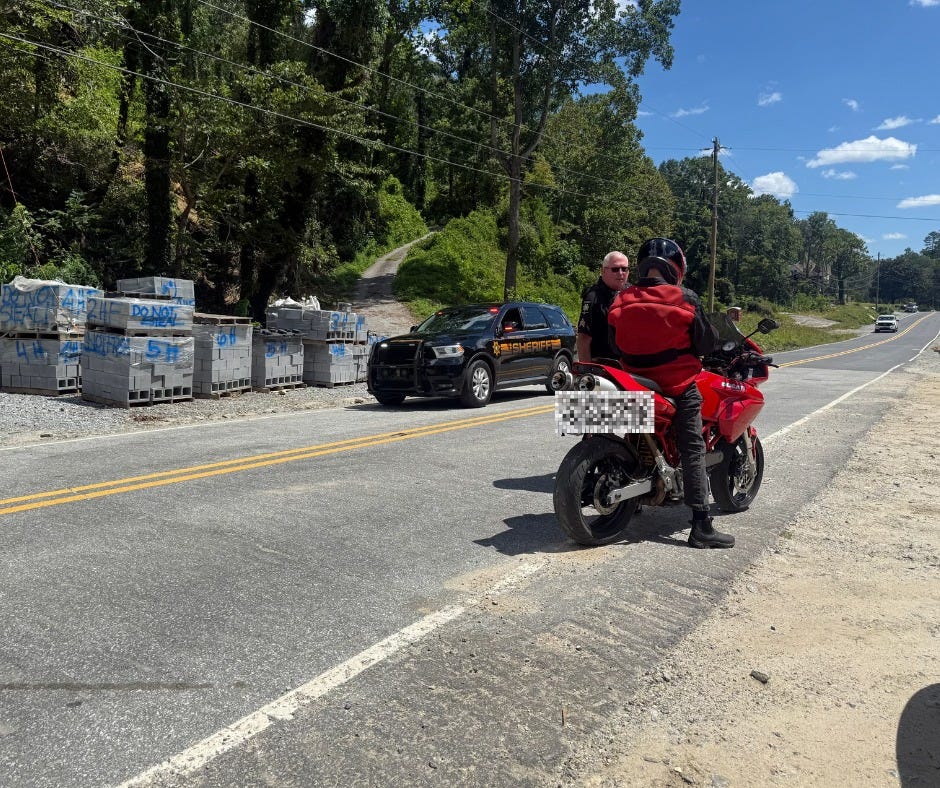 May be an image of 2 people, motorcycle, scooter and road