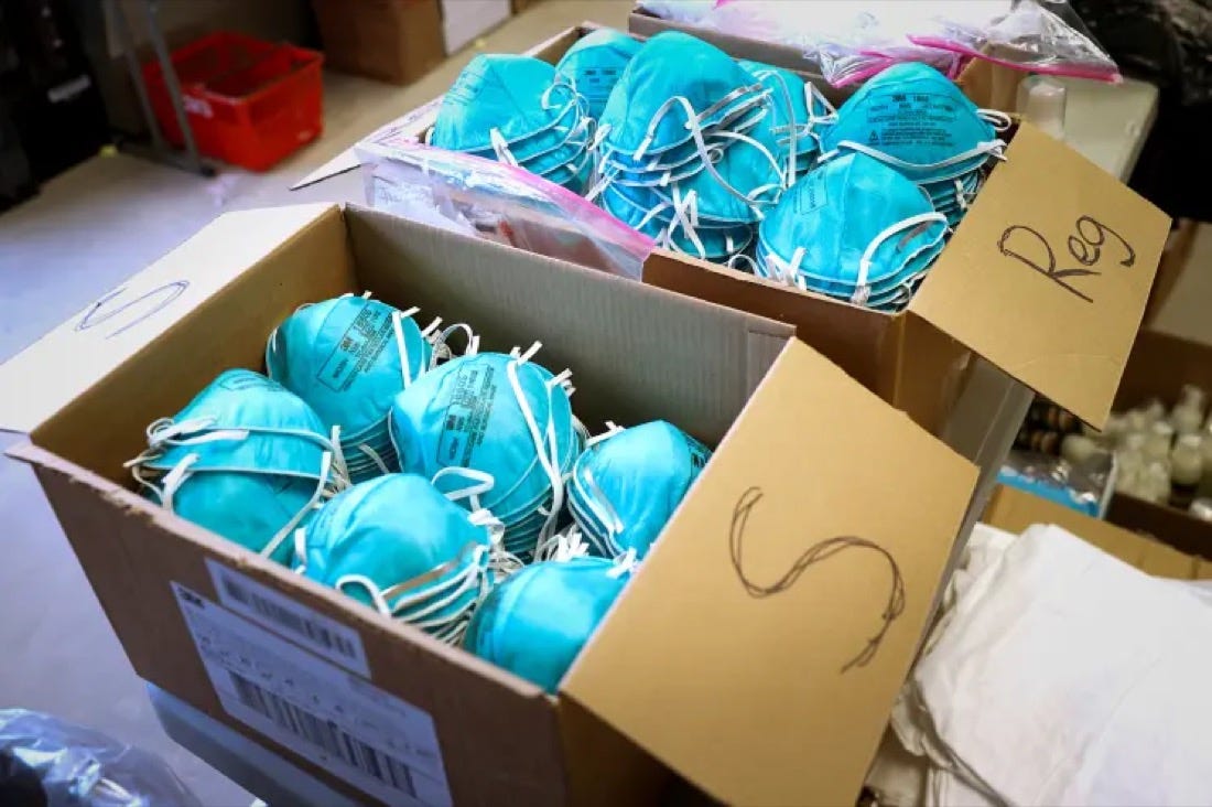 Open cardboard boxes filled with blue N95-style respirator masks. Open cardboard boxes filled with blue N95-style respirator masks.