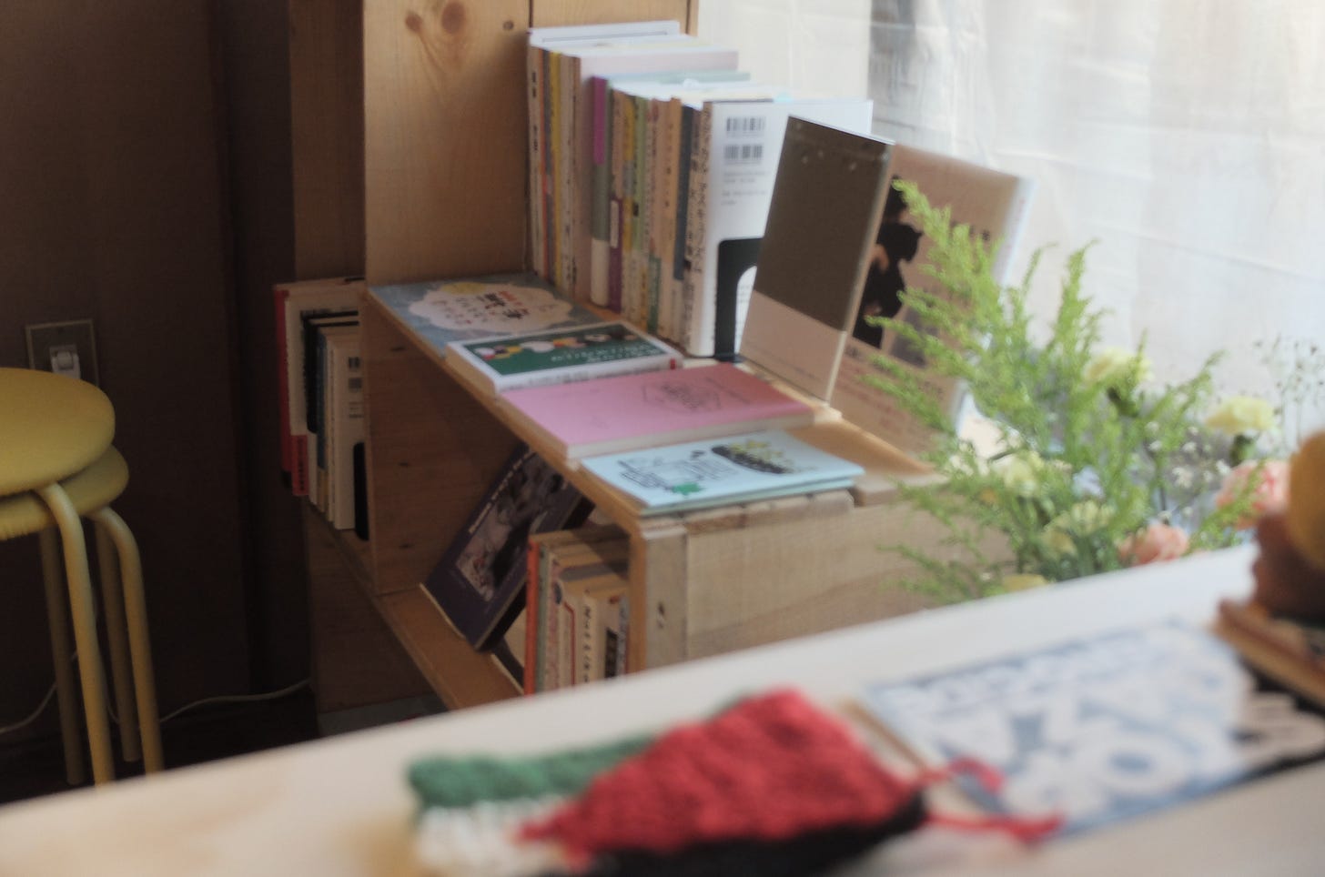 店内の画像。木製のカウンター越しに、窓際に置かれた本棚が見えている。