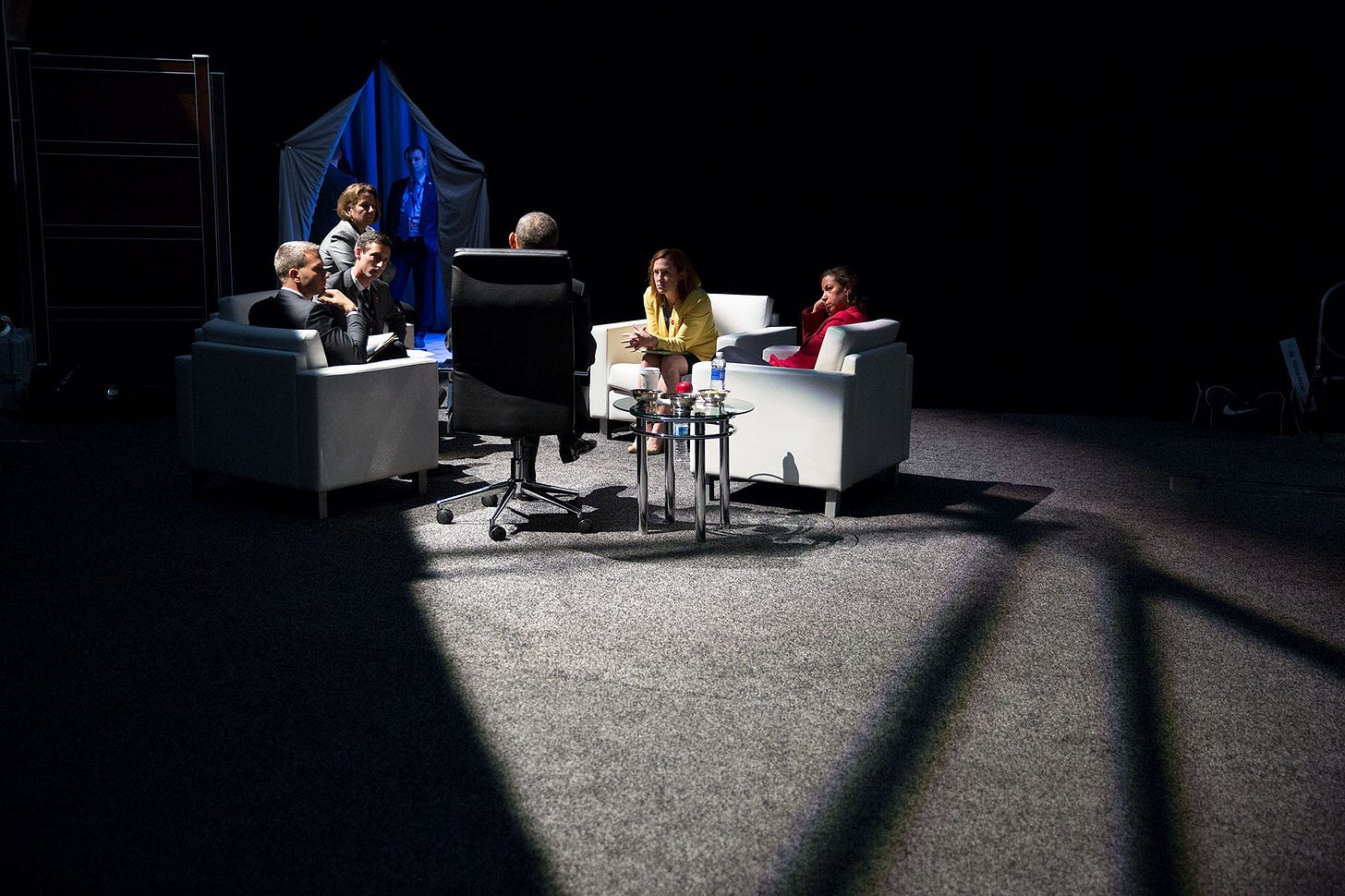 April 1, 2016: Backstage at the Nuclear Security Summit in Washington, D.C., President Obama confers with aides before his press conference, bathed in a shaft of filtering sunlight. April 1, 2016: Backstage at the Nuclear Security Summit in Washington, D.C., President Obama confers with aides before his press conference, bathed in a shaft of filtering sunlight.