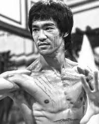 Bruce Lee is shown in this iconic photograph from the 1973 film Enter the  Dragon. The image captures him with scratch marks on his face and chest,  which are a result of