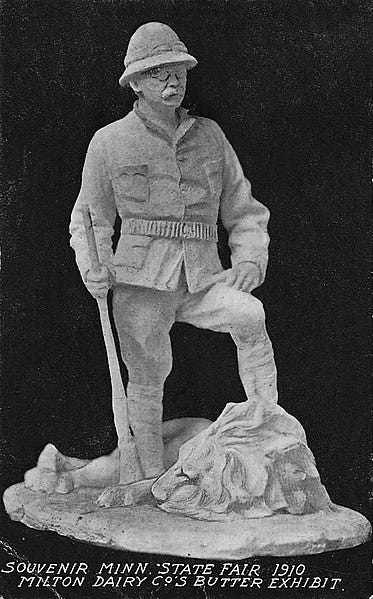 A butter statue of Theodore Roosevelt standing beside a lion