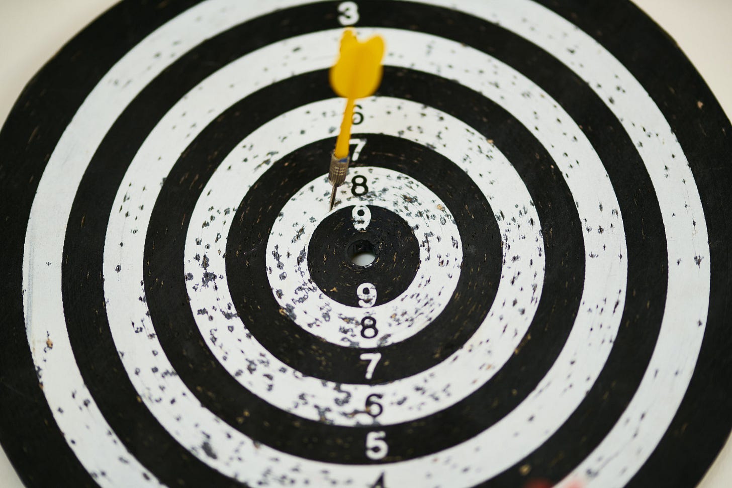 Yellow dart on black and white dartboard Yellow dart on black and white dartboard