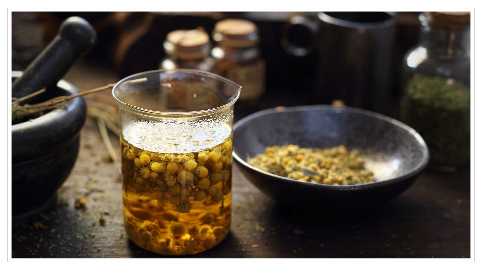 Chamomile flowers making tea in beaker