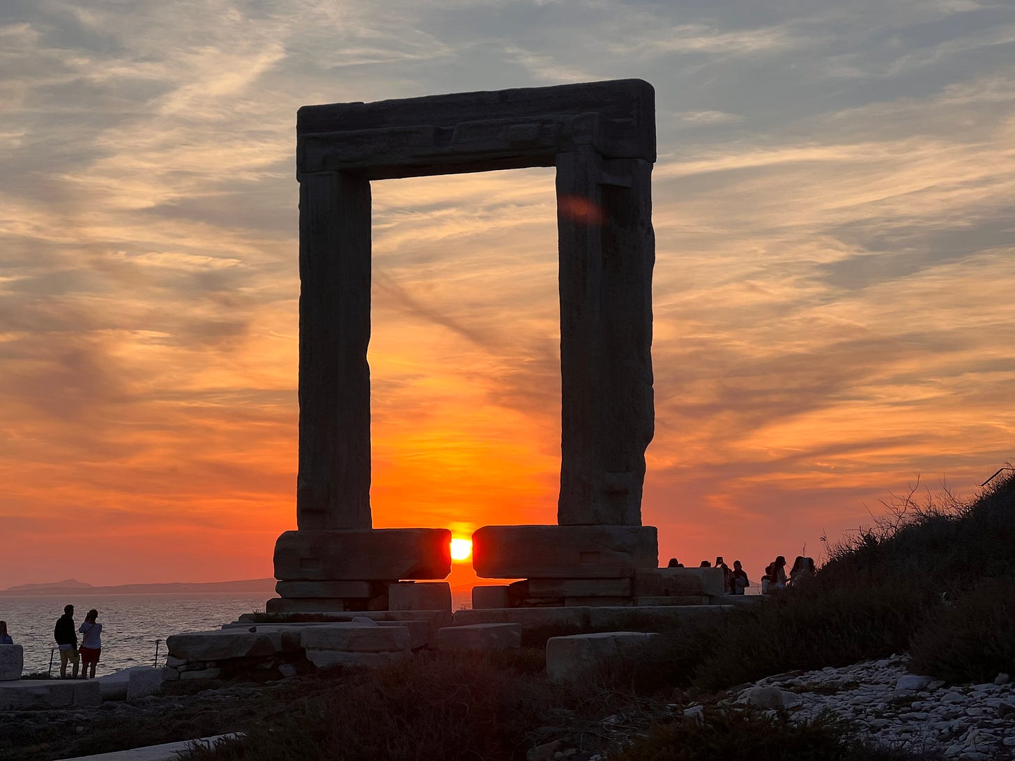 Photo of a large stone arch on top of a mountain with the sun setting in the background. Photo of a large stone arch on top of a mountain with the sun setting in the background.