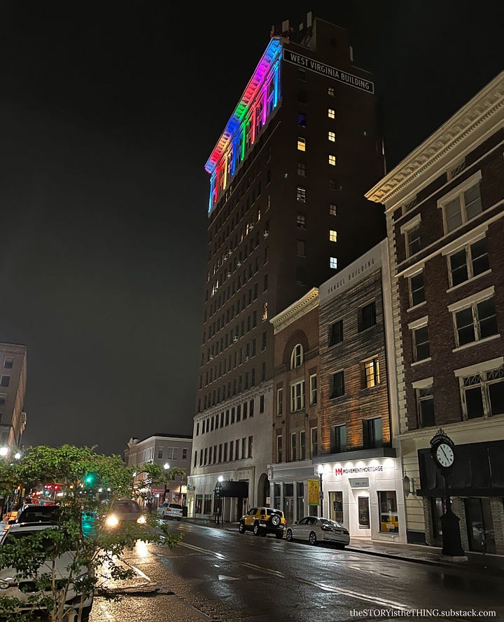 Four views of a downtown apartment building all light up in Pride Month colors in Huntington, West Virginia.