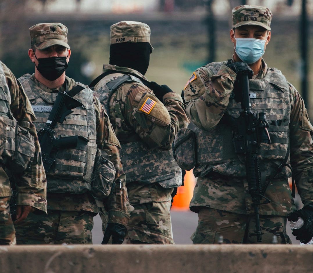 men in camouflage uniform standing on field during daytime