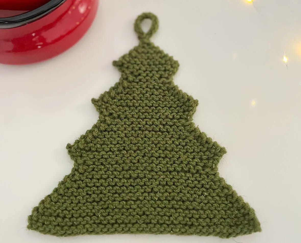 green knitted potholder in the shape of a Christmas tree