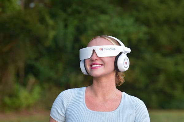 Photograph of a woman wearing BrainTap headset and smiling