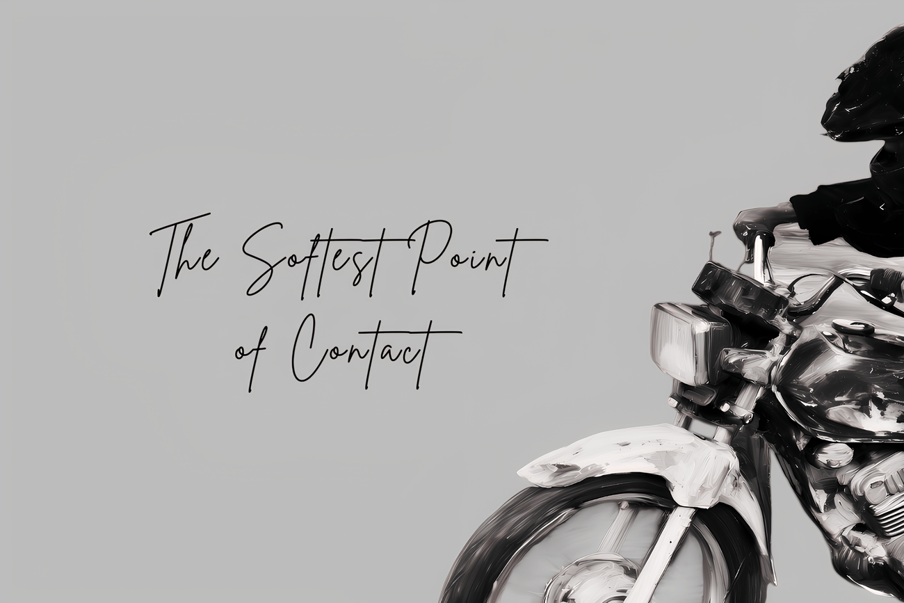 Black-and-white motorcycle art header for "The Softest Point of Contact." A wide-crop digital painting featuring minimalist negative space, handwritten script typography, and textured mechanical details of a motorbike wheel.