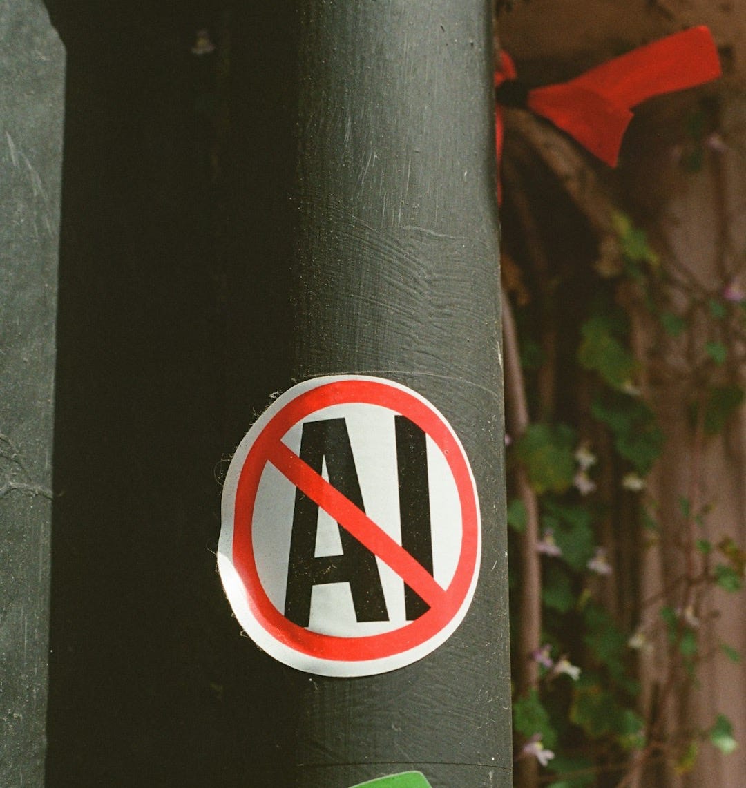 No ai! sticker on a dark pole with green advertisement. No ai! sticker on a dark pole with green advertisement.