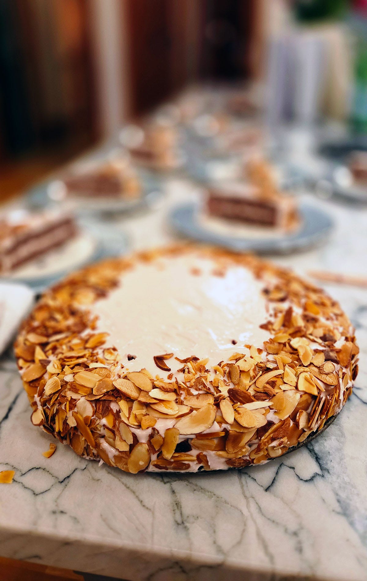 A chokecherry cake on a counter with slices of the cake behind it. A chokecherry cake on a counter with slices of the cake behind it.