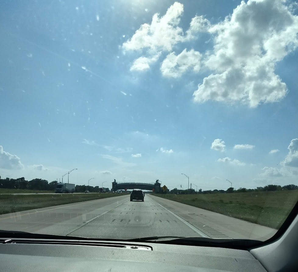 On freeway, looking at large arch building over the road On freeway, looking at large arch building over the road