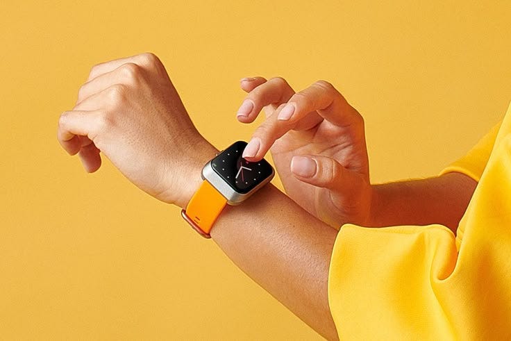 This may contain: a woman in a yellow shirt is holding onto an apple watch band with her hand