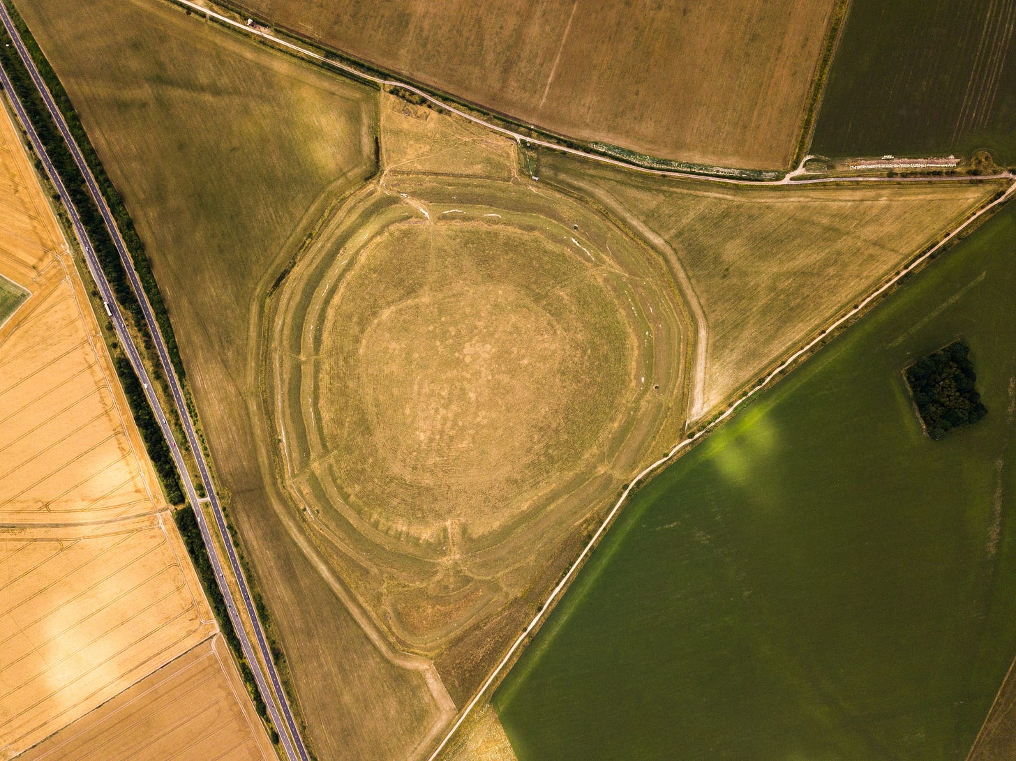 Explore the aerial perspective of an ancient henge surrounded by farmland in England.