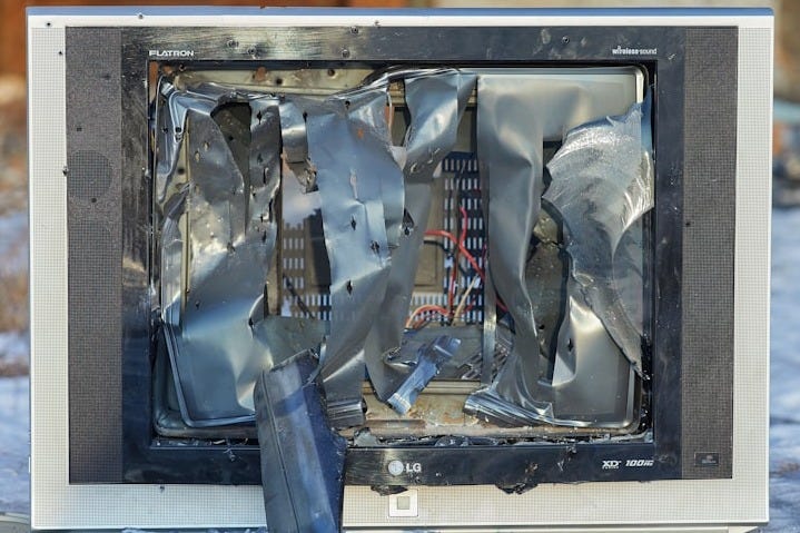a broken television sitting on top of snow covered ground