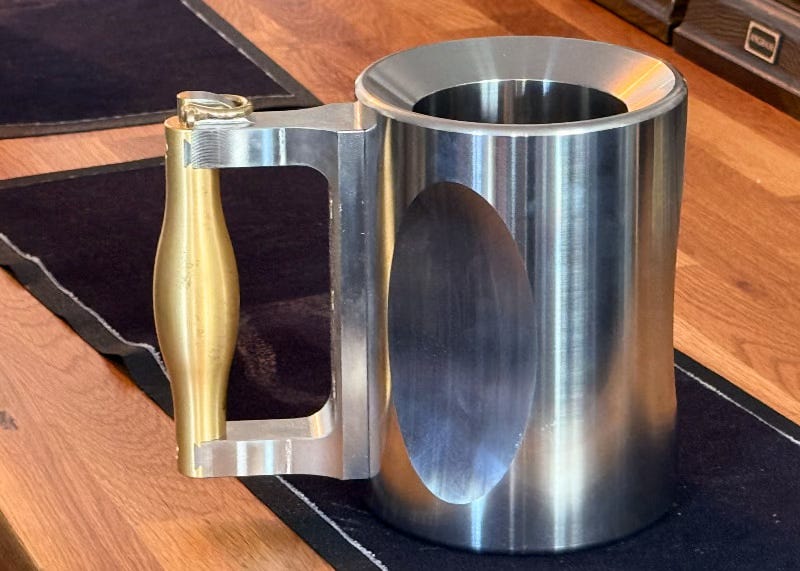A large stainless steel and brass tankard. A large stainless steel and brass tankard.