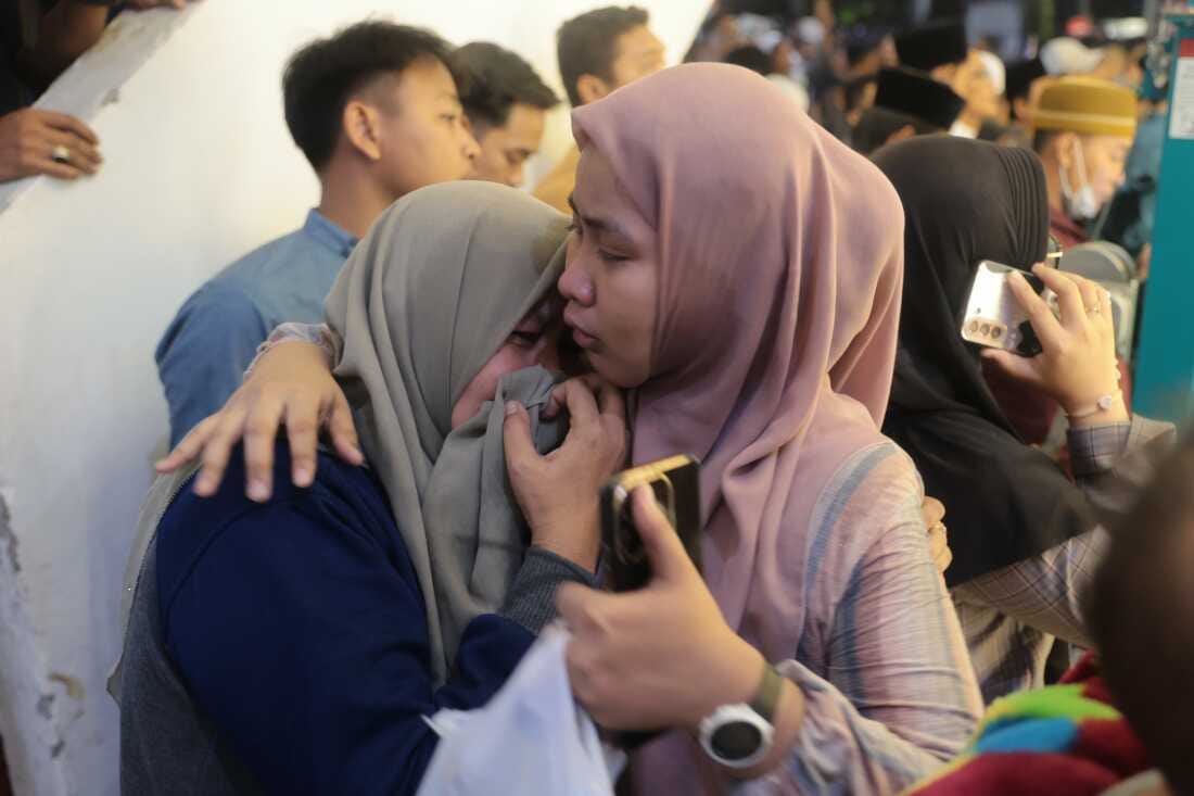 A woman is comforted as she weeps while rescue work is underway after a building collapsed at an Islamic boarding school in Sidoarjo, East Java, Indonesia, on Sept. 29, 2025. (AP Photo/Trisnadi)
