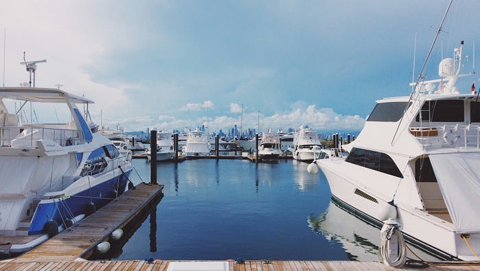 A marine full of yachts tied up at the docks, ready to sail out over a beautiful clear ocean. A marine full of yachts tied up at the docks, ready to sail out over a beautiful clear ocean.