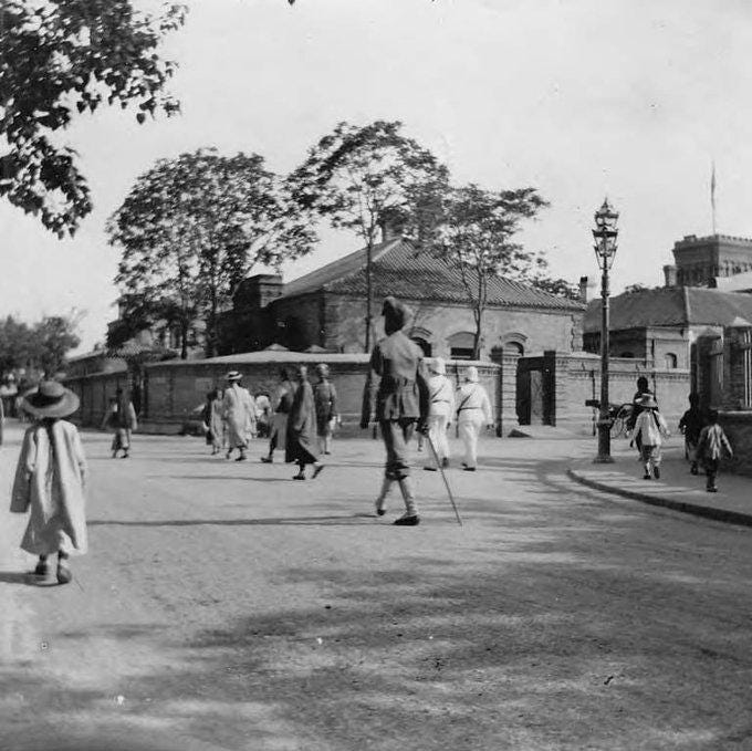 An Indian policeman walking on a road in Tianjin, China, 1898.