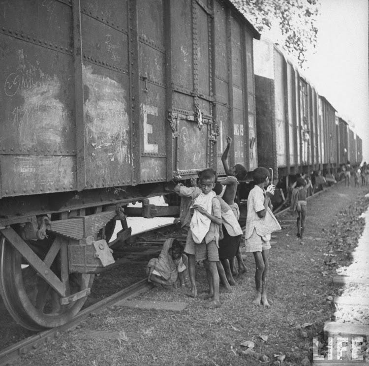 Children poking grain cars with wires, trying to pierce bags and pull grain down into bags Children poking grain cars with wires, trying to pierce bags and pull grain down into bags