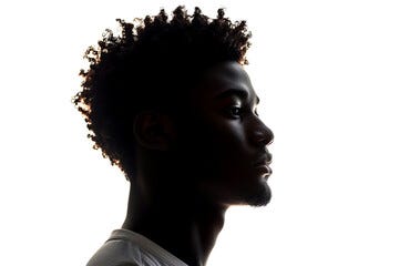 Dark silhouette of young african american man on white background, side view.