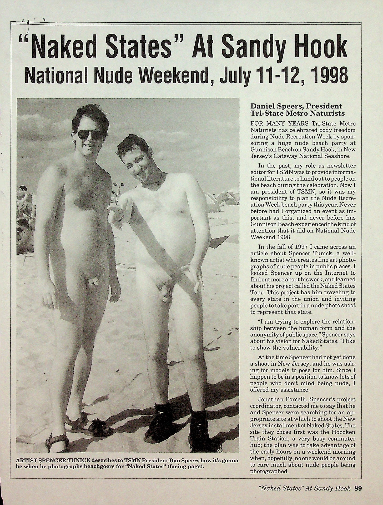 A black-and-white magazine page with an article titled “Naked States at Sandy Hook: National Nude Weekend, July 11–12, 1998.” The photo shows artist Spencer Tunick and TSMN president Dan Speers standing nude on the beach, posing for the camera with relaxed expressions. Tunick wears sunglasses; both men have sand at their feet and beachgoers blur into the background. The accompanying article describes Tunick’s collaboration with Tri-State Metro Naturists to photograph volunteers for his Naked States project. A black-and-white magazine page with an article titled “Naked States at Sandy Hook: National Nude Weekend, July 11–12, 1998.” The photo shows artist Spencer Tunick and TSMN president Dan Speers standing nude on the beach, posing for the camera with relaxed expressions. Tunick wears sunglasses; both men have sand at their feet and beachgoers blur into the background. The accompanying article describes Tunick’s collaboration with Tri-State Metro Naturists to photograph volunteers for his Naked States project.