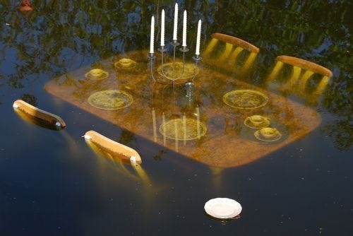 This may contain: the table is surrounded by candles and empty wine bottles in the middle of the water