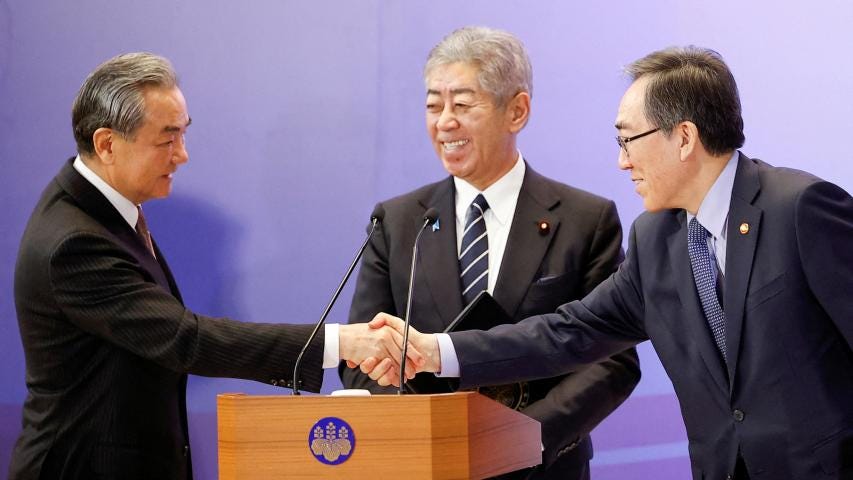 El ministro de Asuntos Exteriores de China, Wang Yi, y el ministro de Asuntos Exteriores de Corea del Sur, Cho Tae-yul, se estrechan la mano mientras el ministro de Asuntos Exteriores de Japón, Takeshi Iwaya.