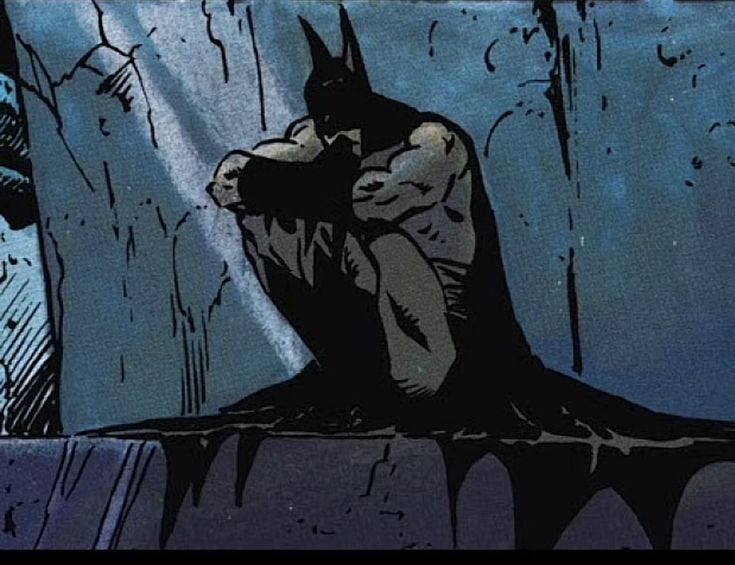 This may contain: the dark knight is sitting in the rain with his hands on his head and eyes closed