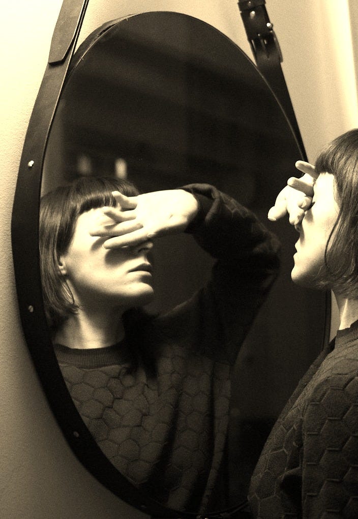 woman in black long sleeve shirt standing in front of mirror woman in black long sleeve shirt standing in front of mirror