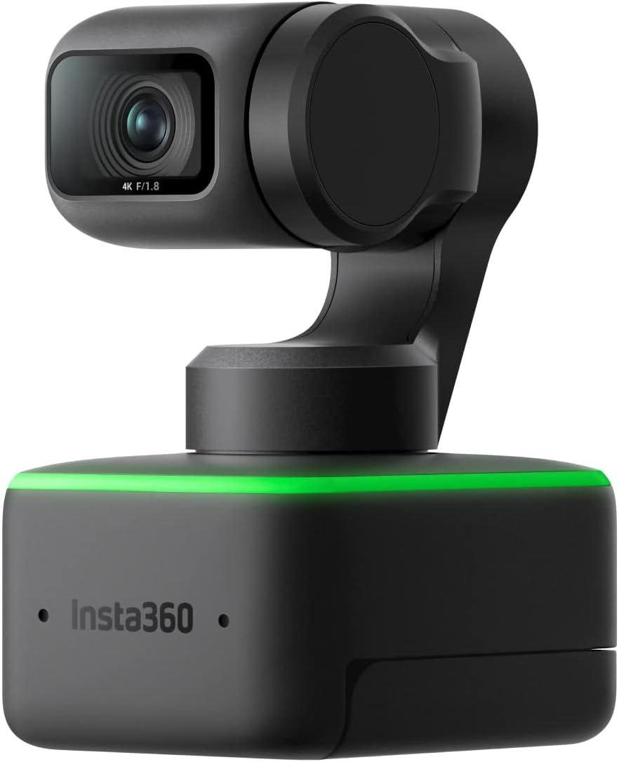 Insta360 Link 4K webcam in matte black with motorized gimbal design. The camera features a 4K F/1.8 lens visible on the left side and is mounted on a rotating arm connected to a square base with an illuminated green LED strip. The base displays the Insta360 branding and houses the AI tracking technology that enables the camera to follow subjects automatically. This premium webcam is designed for professional video conferencing, live streaming, and content creation with advanced features like auto-framing and gesture controls, making it ideal for sales professionals seeking high-quality video presence during client presentations.