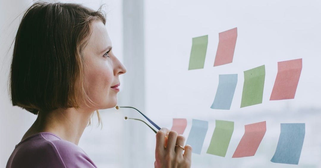 a woman looking out a window with sticky notes on it