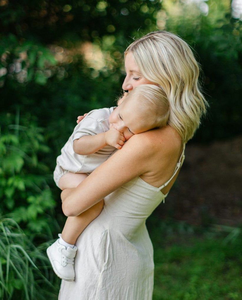 a woman holding a baby in her arms a woman holding a baby in her arms