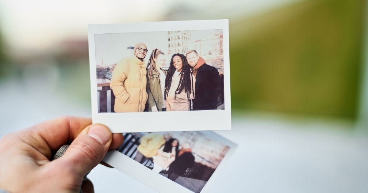 Close-up of a hand holding Polaroid photos 