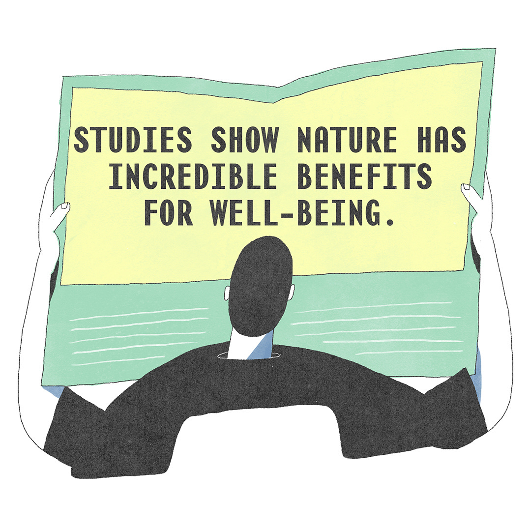 Aerial view of him holding up a research paper which says in bold, “Studies show nature has incredible benefits for well-being”.